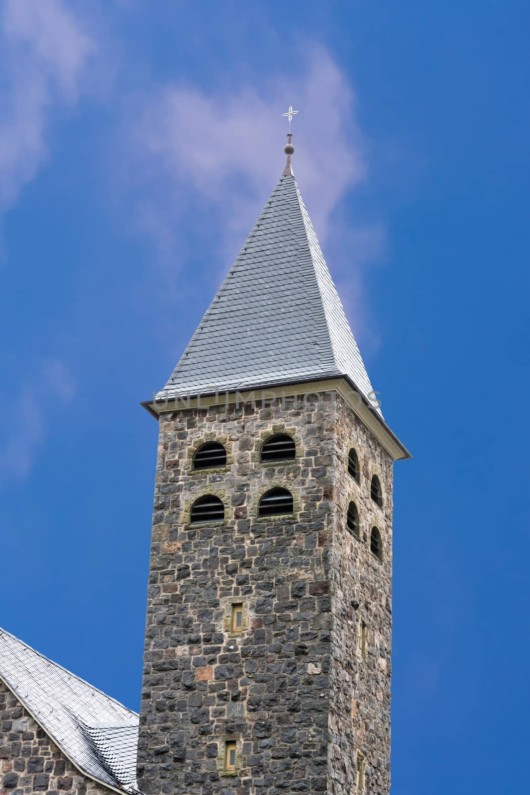 Tower, spire of a church in Antfeld in Sauerland, Germany against blue sky.