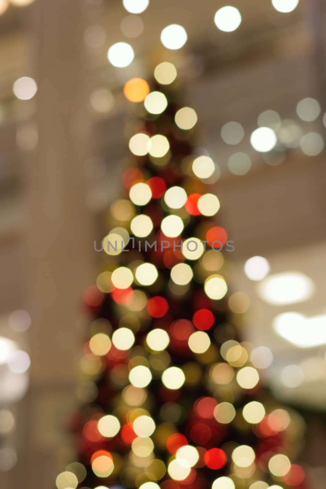 Holiday background - Large Christmas tree blurred lights in vertical frame