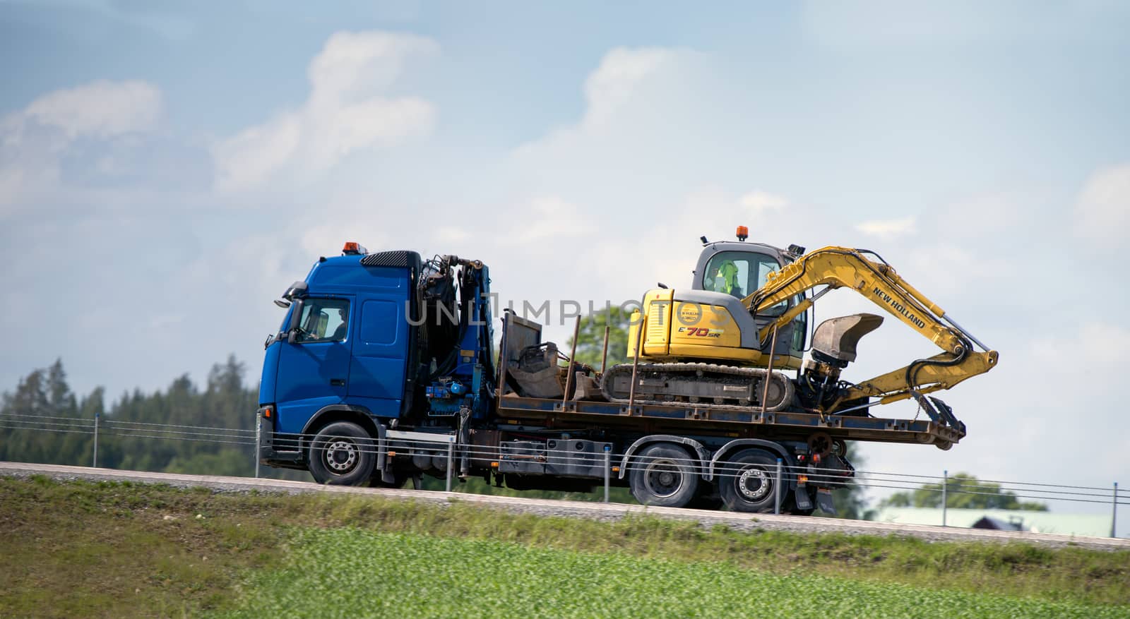 Truck moving a excavator on a country road near Katrineholm