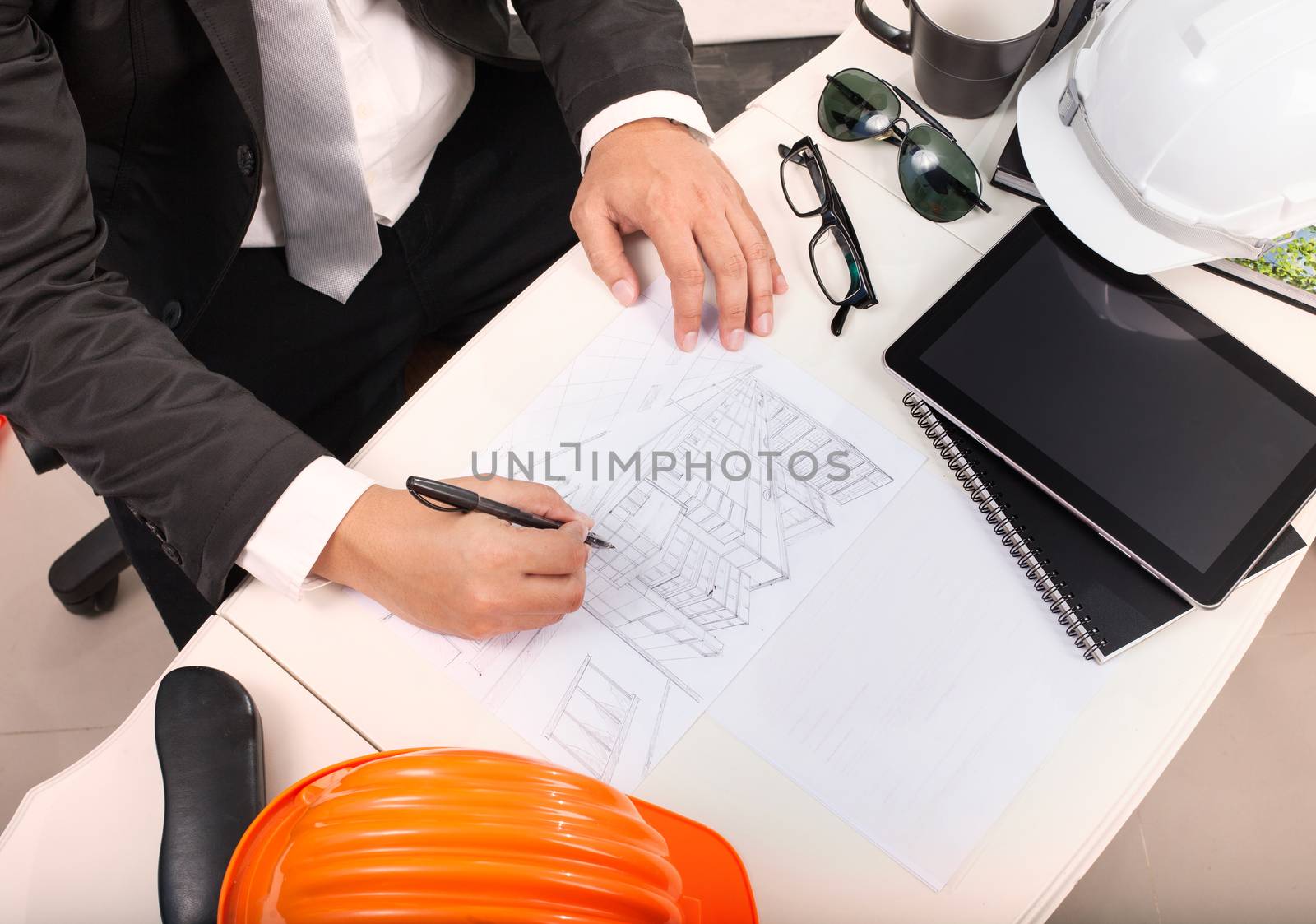 top view of architect working table with drawing perspective building plan and sunglasses ,safety helmet