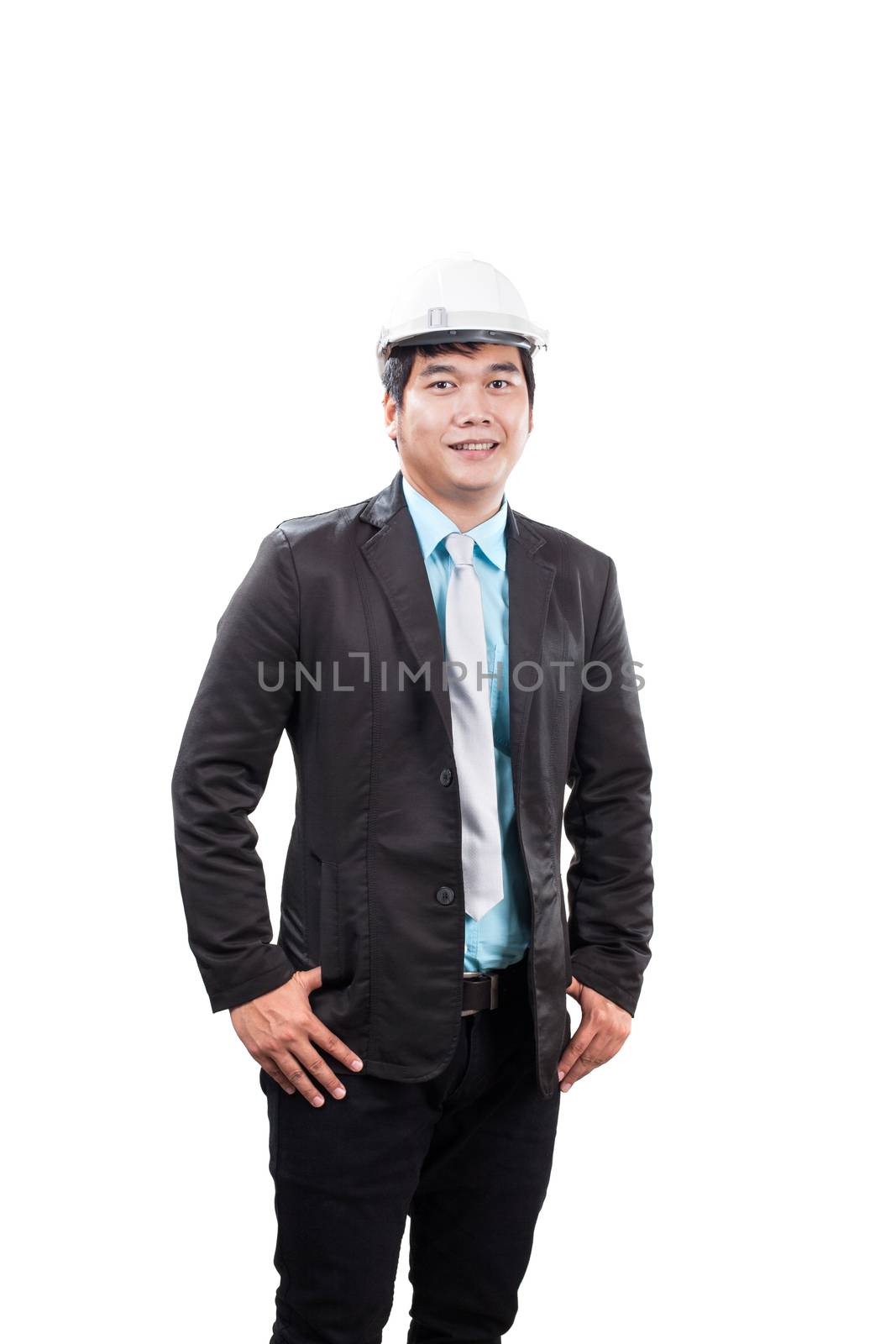 engineering man wearing white safety helmet standing and smiling by khunaspix
