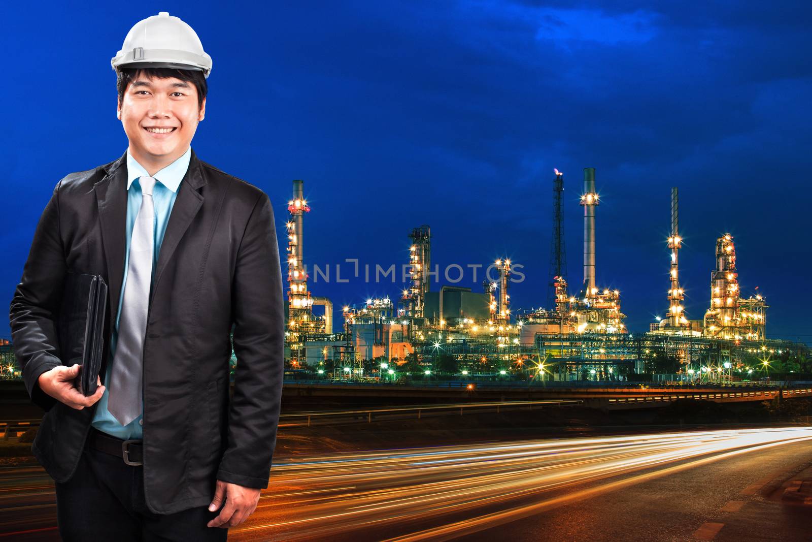 engineering man and oil refinery plant against beautiful blue dusky sky and vehicle lighting on asphalt road use as land transport and oil power industry topic background