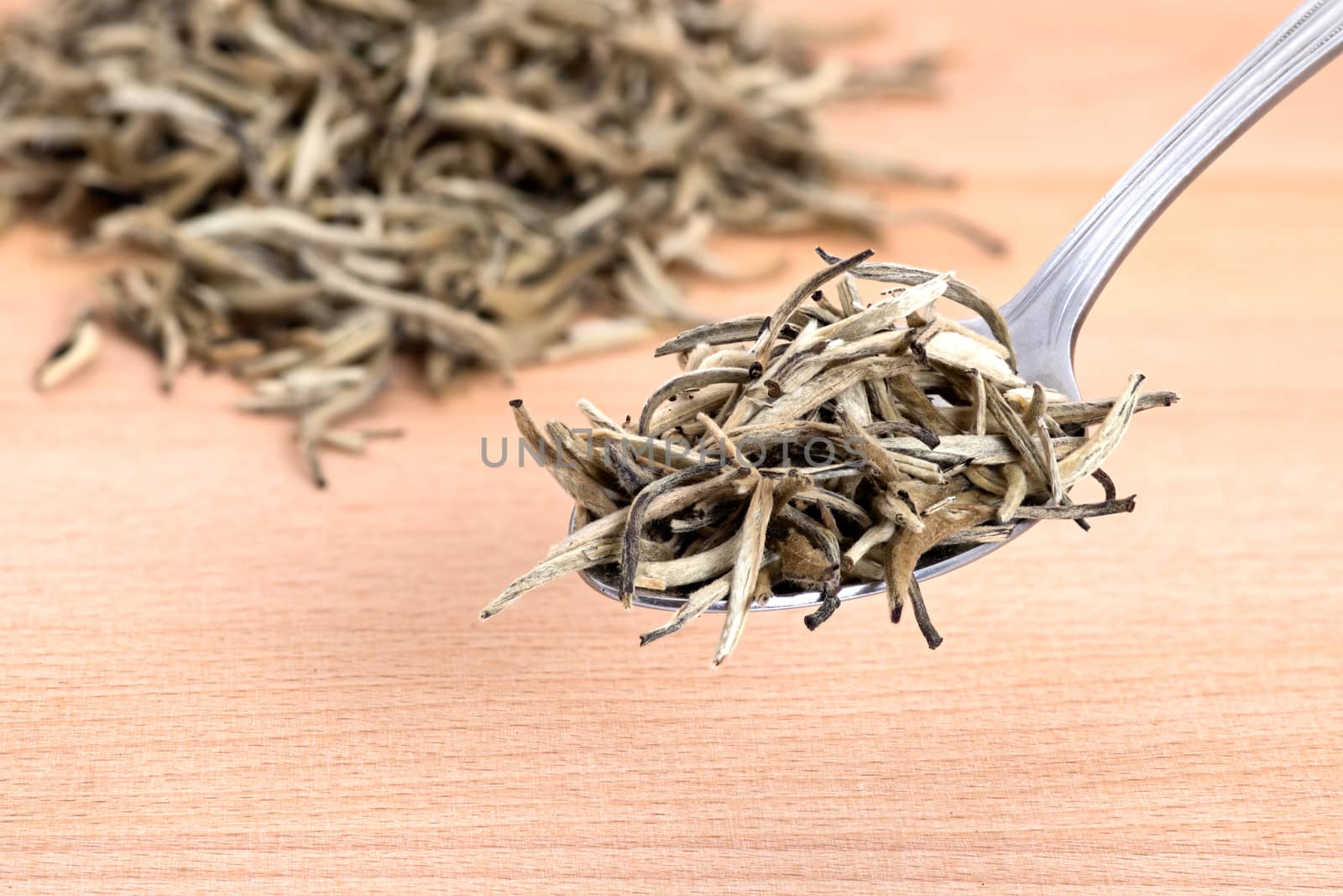 Organic white needle tea on wooden cutting board background