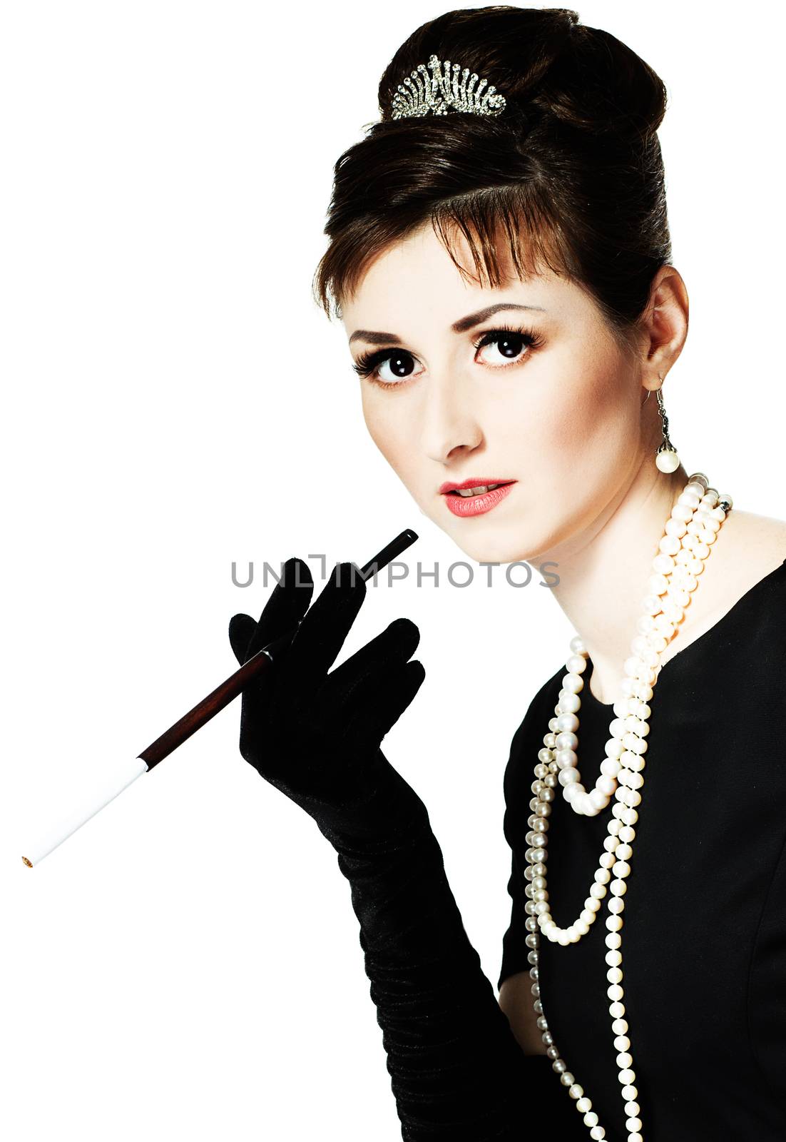 Portrait of a beautiful young woman in retro style with cigarette in mouthpiece in the image of the famous actress Audrey Hepburn. Isolated on white