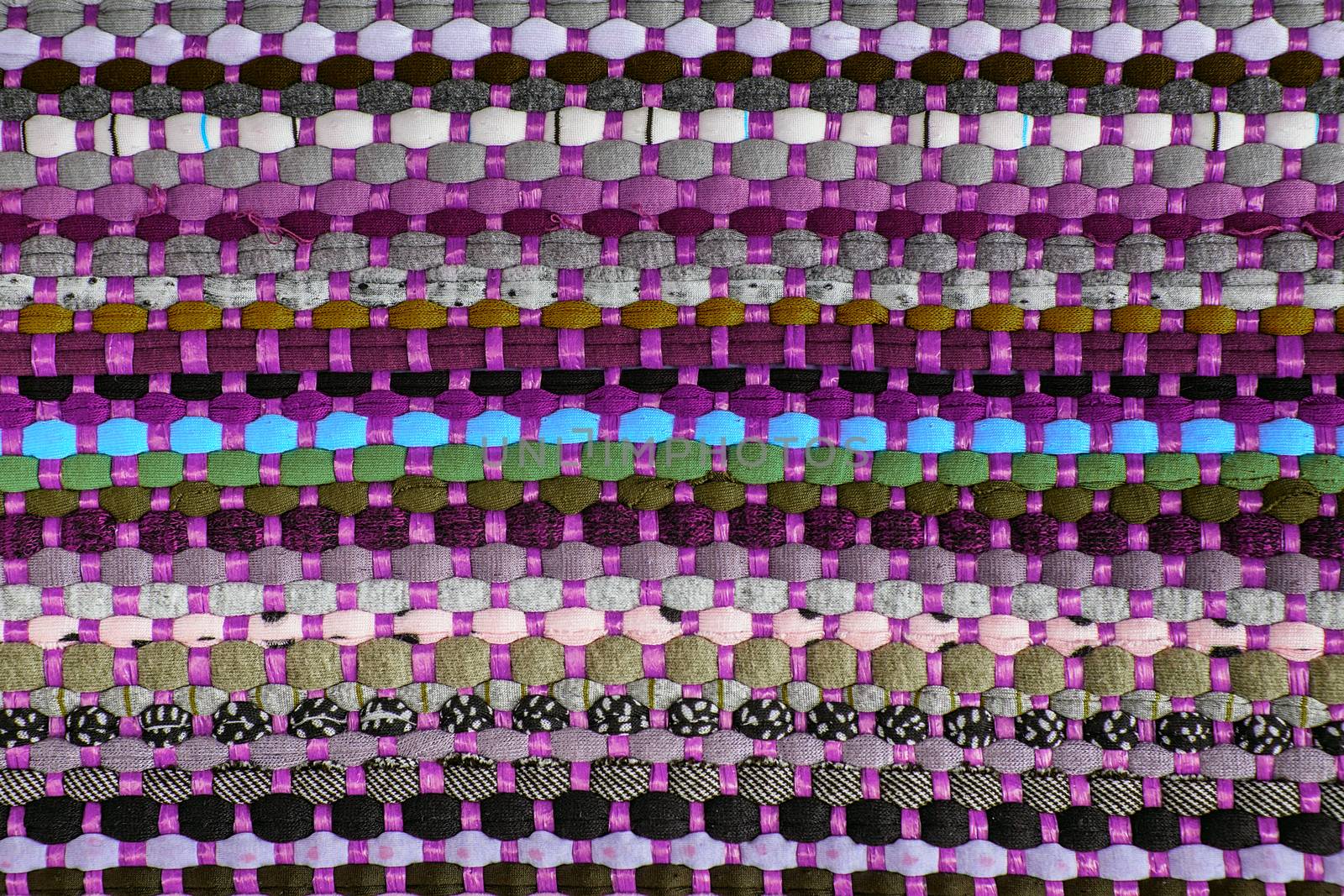 background, texture of colored handmade carpet. Fabric rug of small patches