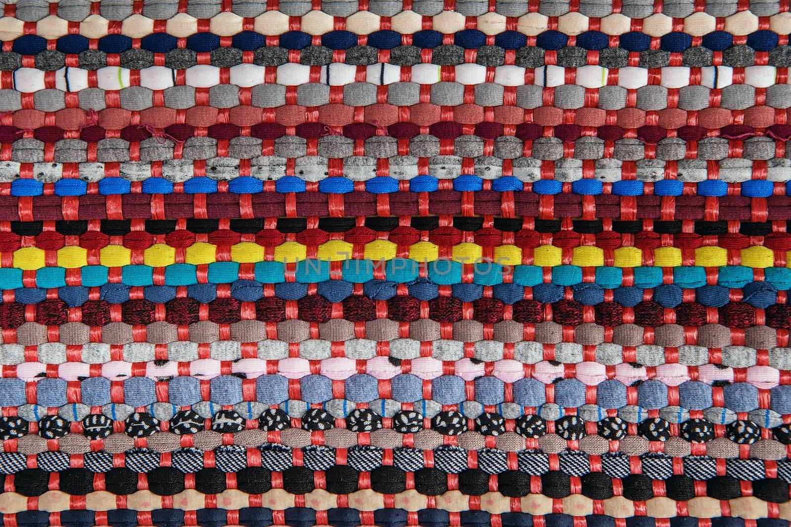 background, texture of colored handmade carpet. Fabric rug of small patches