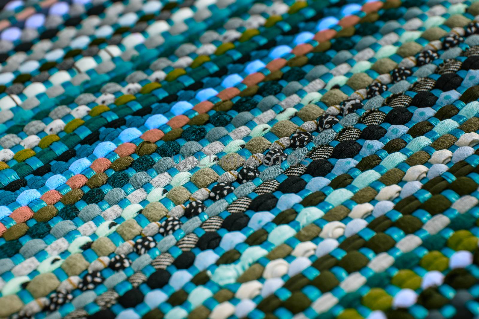 background, texture of colored handmade carpet. Fabric rug of small patches