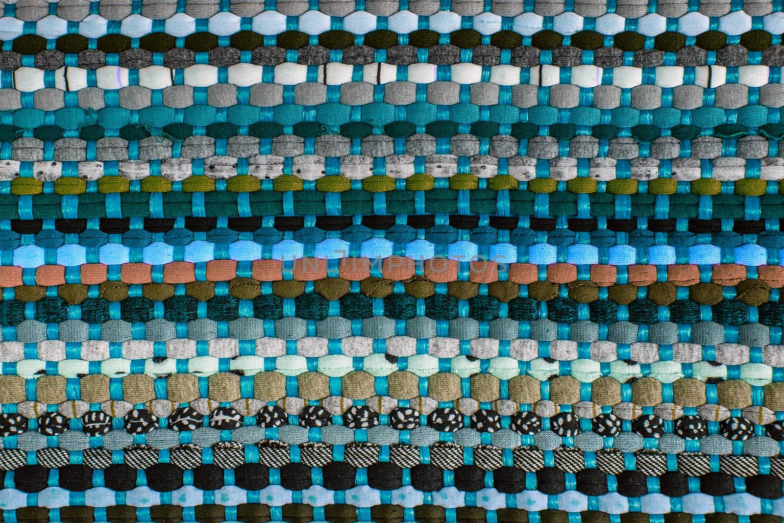 background, texture of colored handmade carpet. Fabric rug of small patches