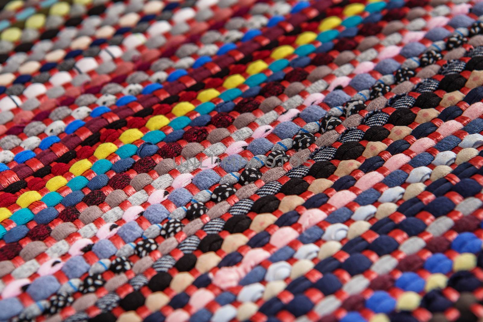 background, texture of colored handmade carpet. Fabric rug of small patches