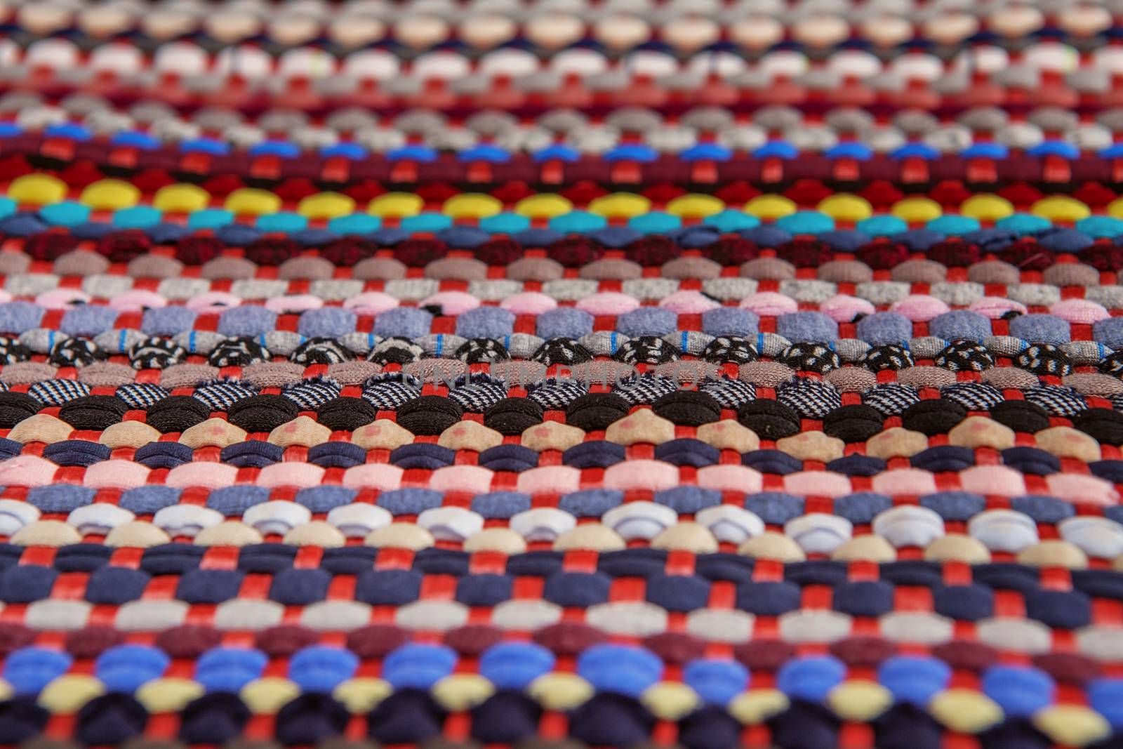 background, texture of colored handmade carpet. Fabric rug of small patches