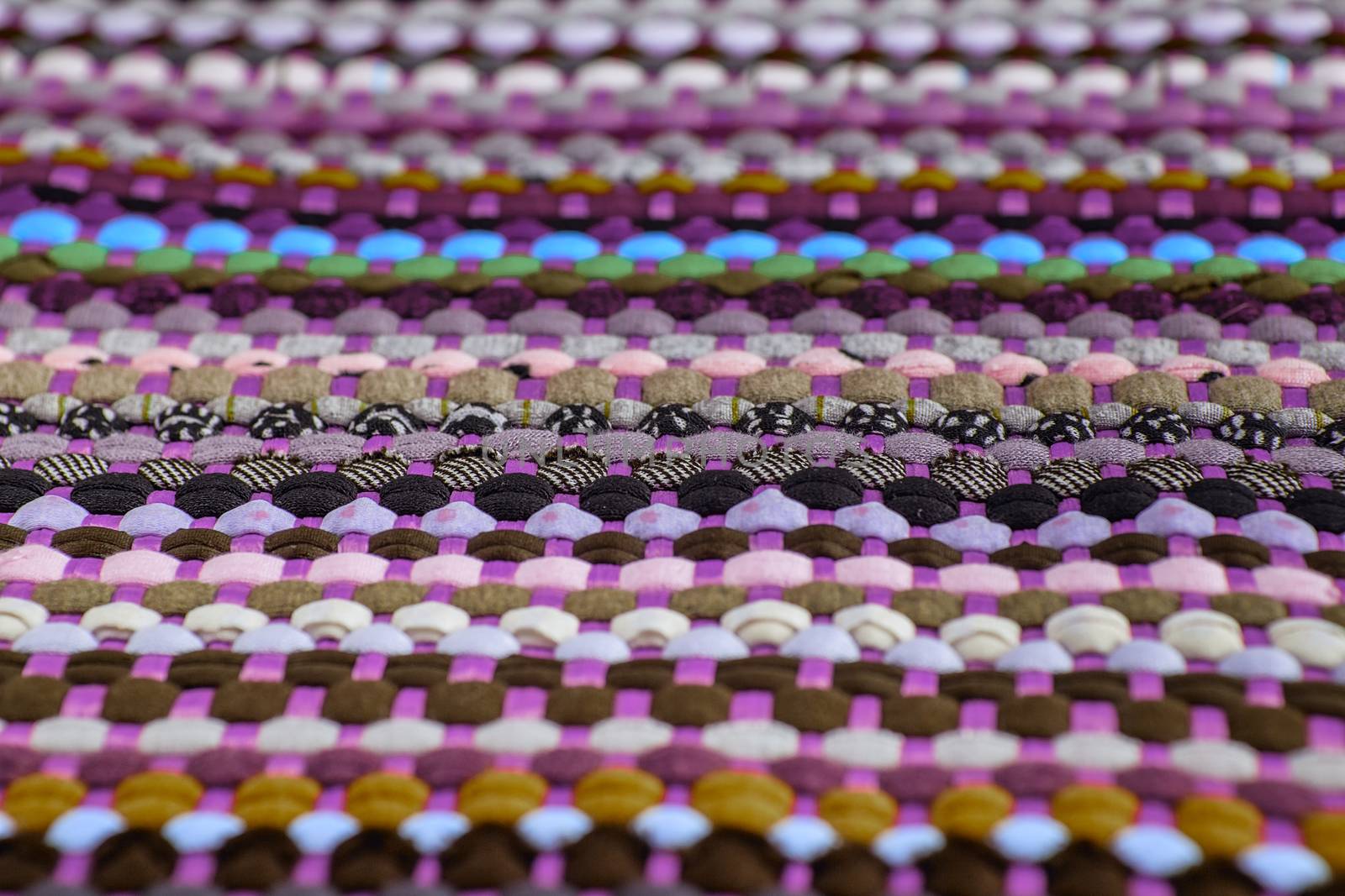 background, texture of colored handmade carpet. Fabric rug of small patches