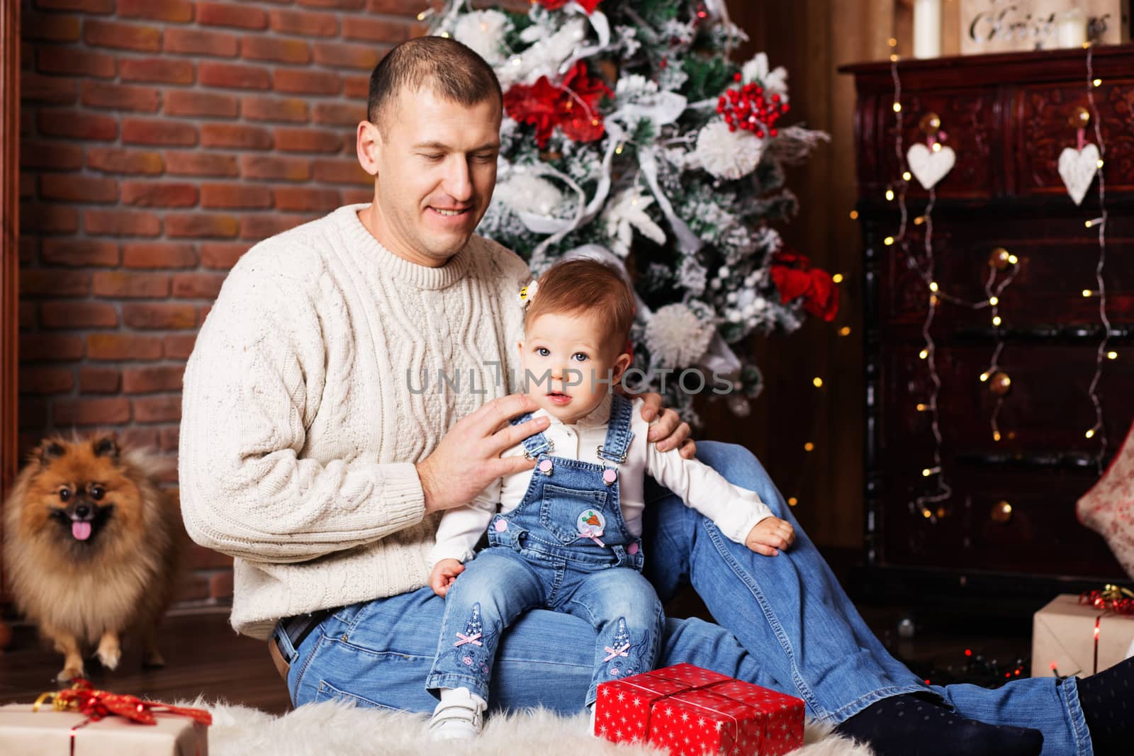 Portrait of happy father and his adorable little daughter among Christmas decorations