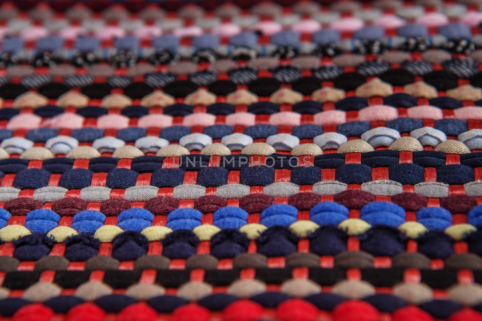 background, texture of colored handmade carpet. Fabric rug of small patches