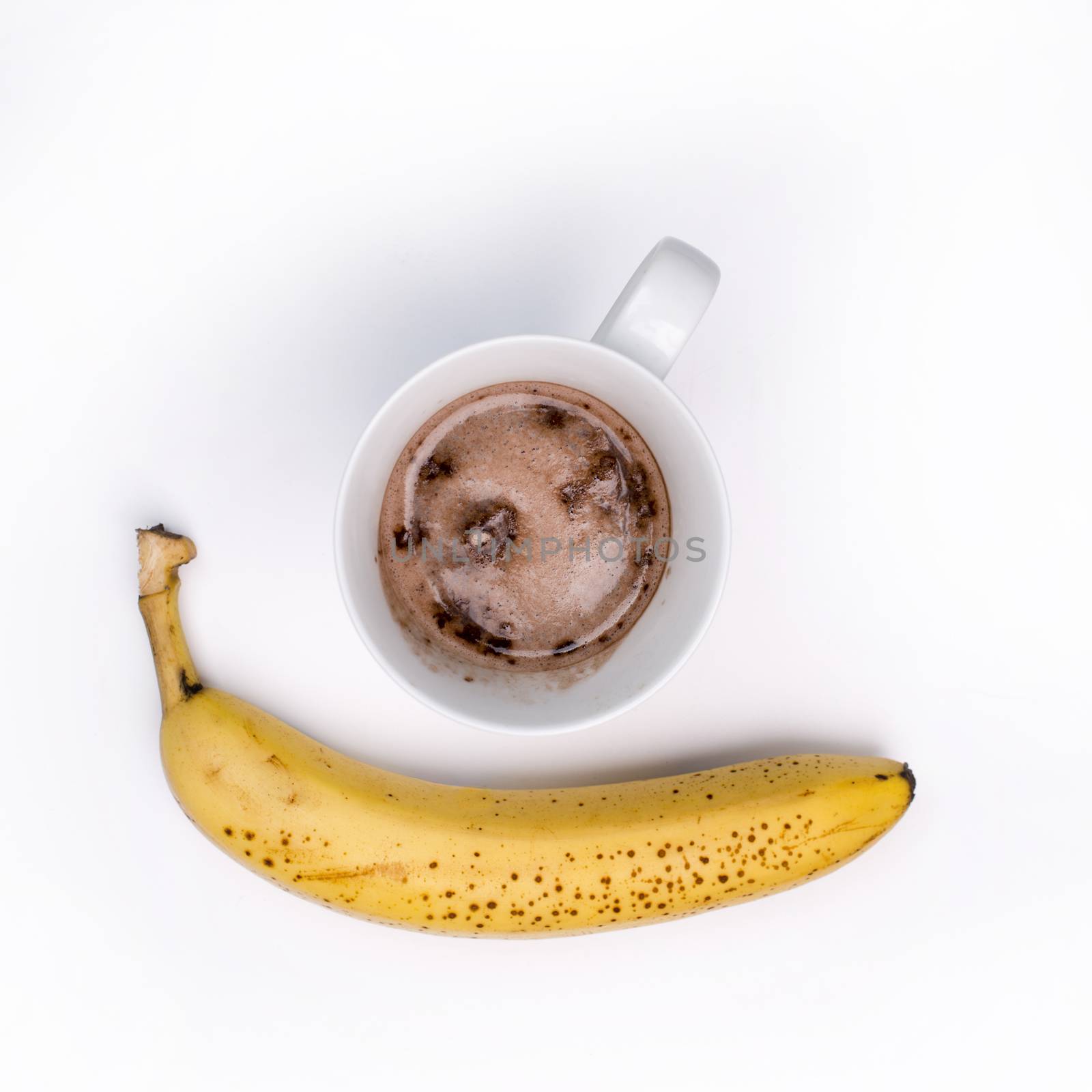 Complete protein Hot Chocolate drink and a banana, isolated on white, overhead shot