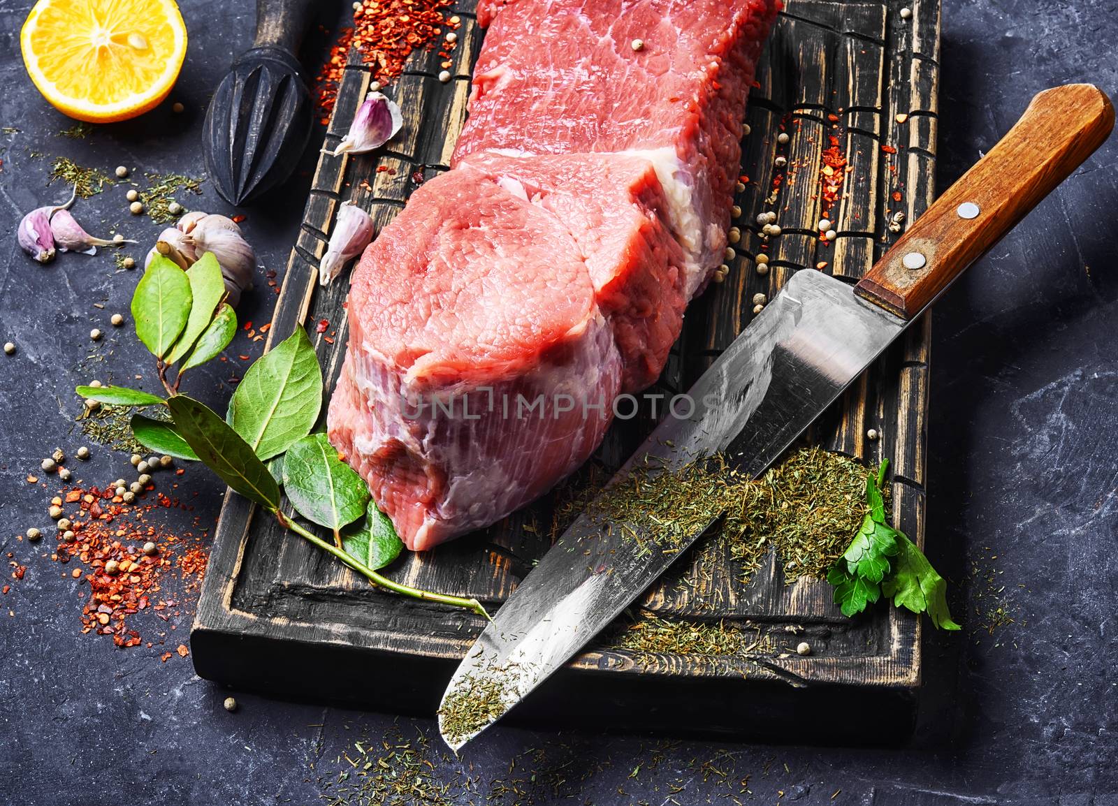 Raw veal meat on kitchen board with spice