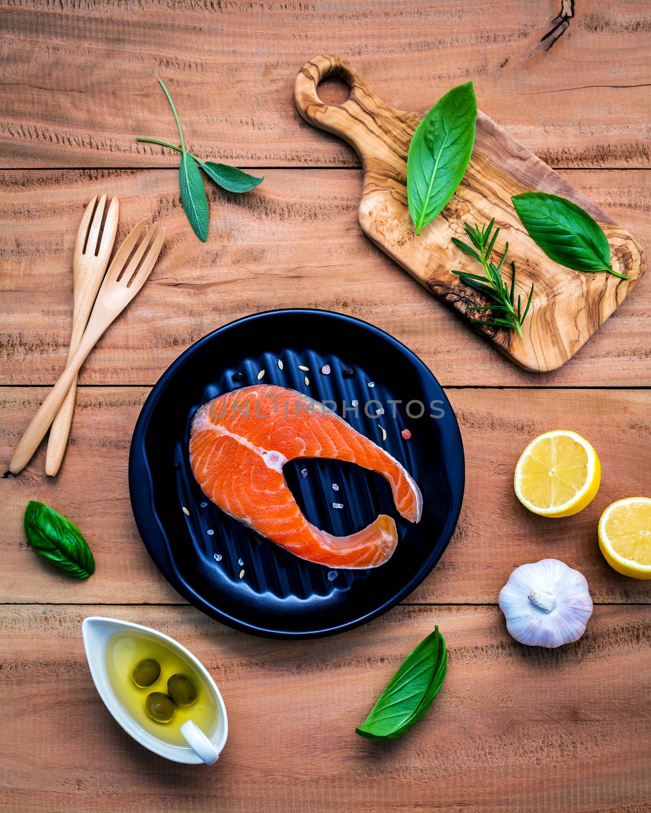 Raw salmon fillet in the black plate with ingredients olive oil  by kerdkanno