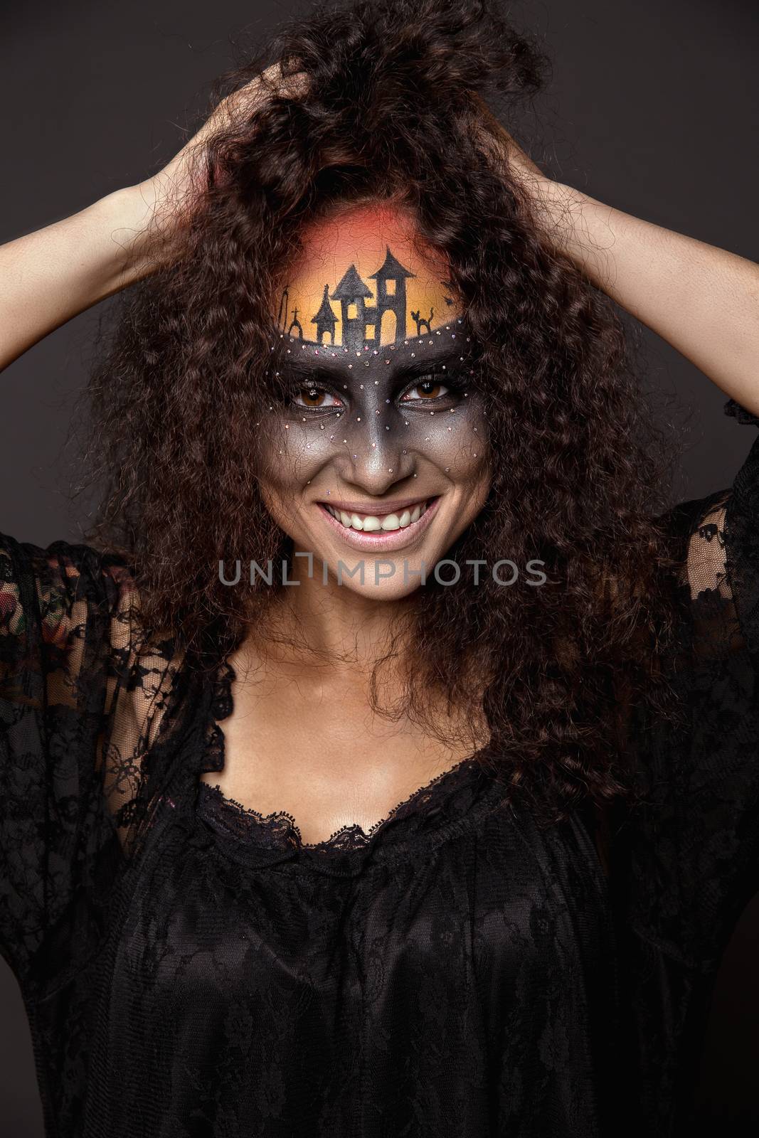 Halloween devil's bride. Portrait of young woman in dark artistic image with scary makeup, veil and terrible picture on her forehead.