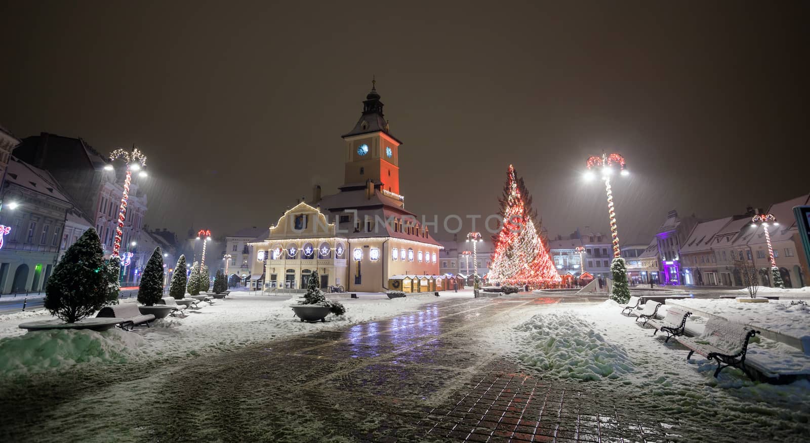 Brasov Council House night view with Christmas Tree decorated and traditional winter market in the old town center, Romania