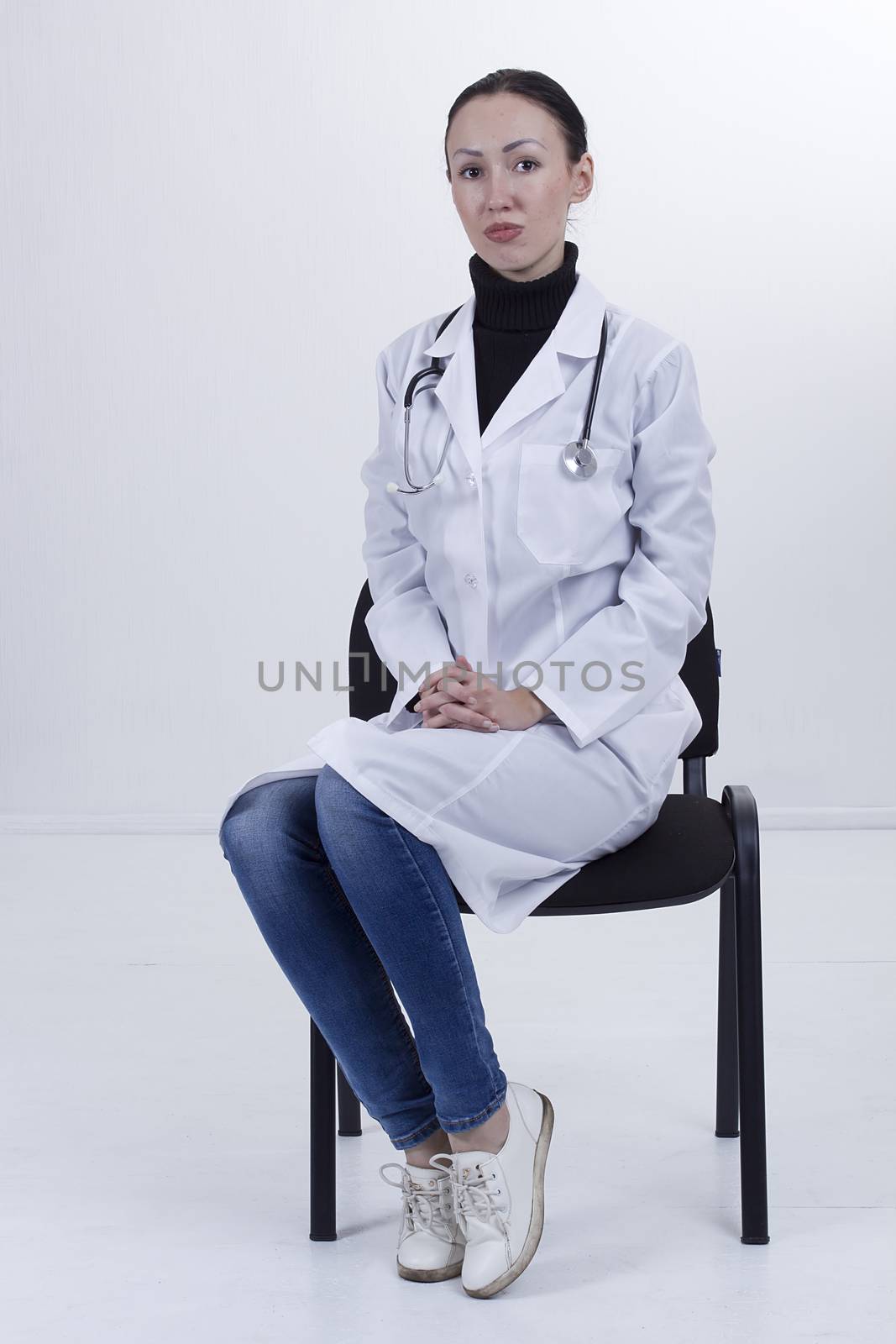Serious female medical student sitting on chair