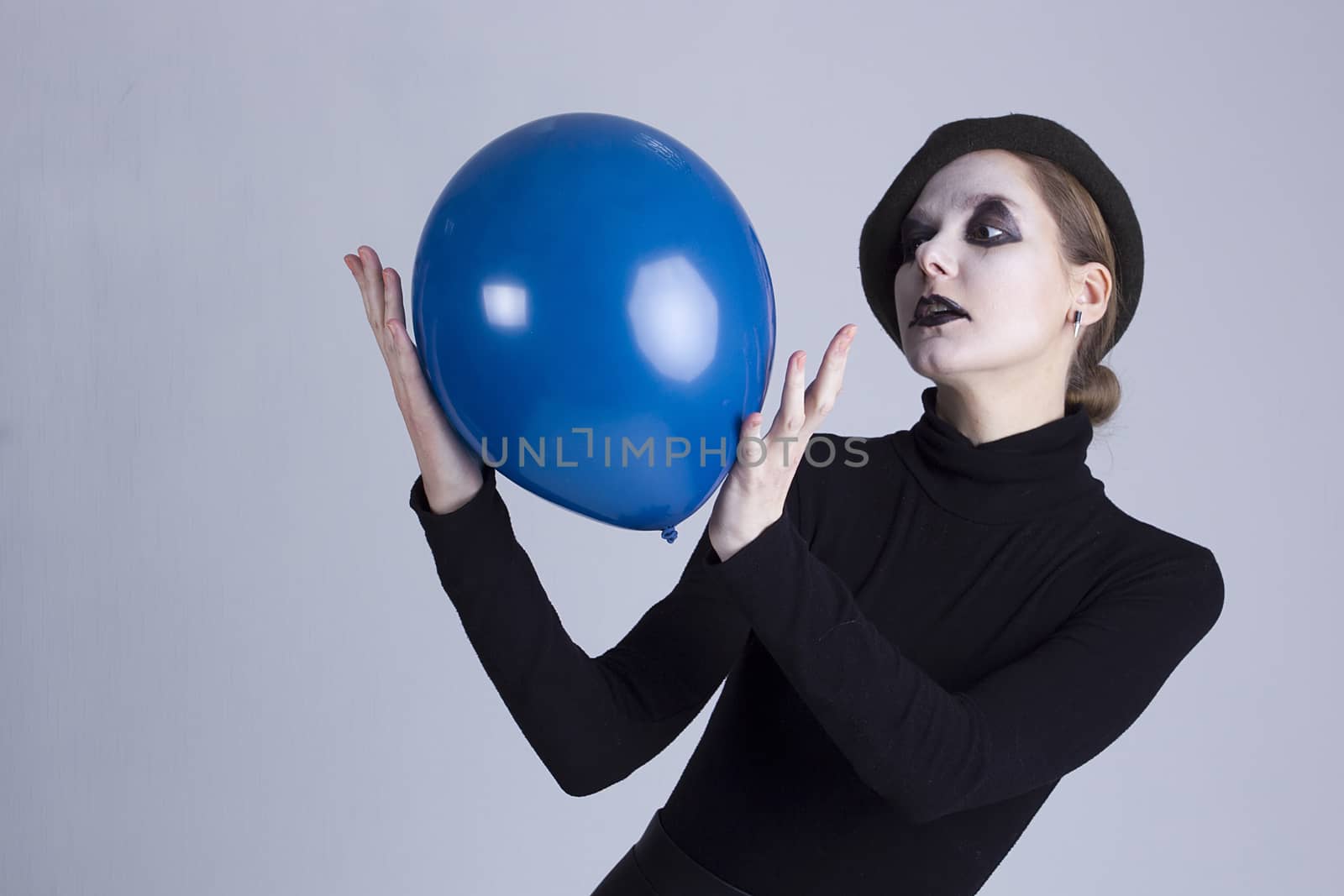 Young woman mime with blue ball