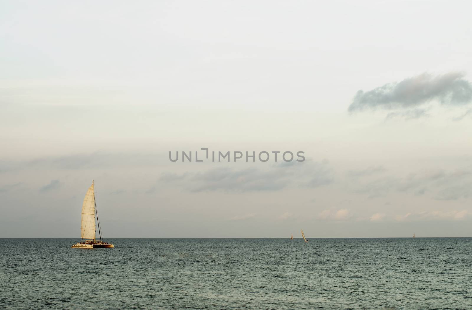 Lonely Sailboat on Mediterranean Sea Horizon in Summer Evening on Cloudy Sky background Outdoors