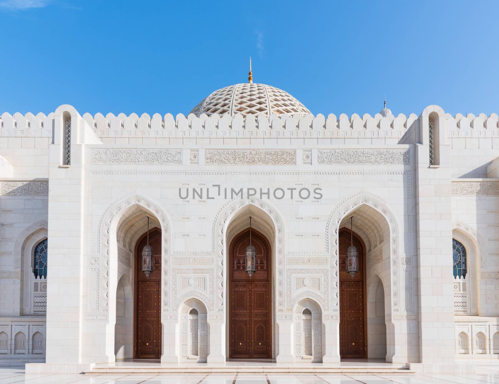 Exterior detail with entrance doors and the dome in the background of the Sultan Qaboos Grand Mosque in Muscat, the main mosque of The Sultanate of Oman.
