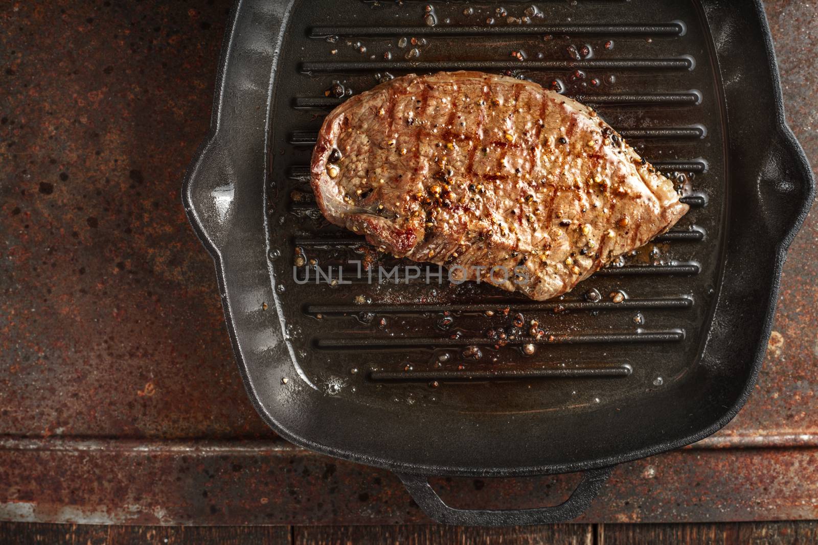 Roast beef steak in spices on pan grill by Deniskarpenkov