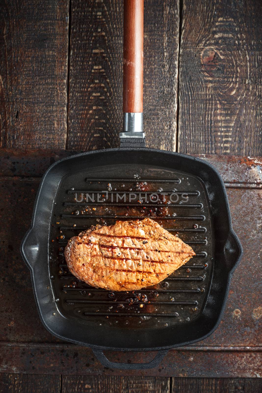 Roast beef steak on pan grill on the table by Deniskarpenkov