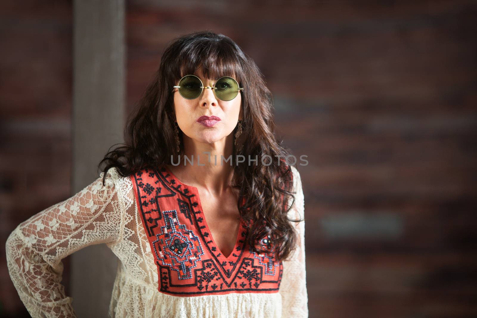 Serious beautiful adult woman in round sunglasses indoors with copy space