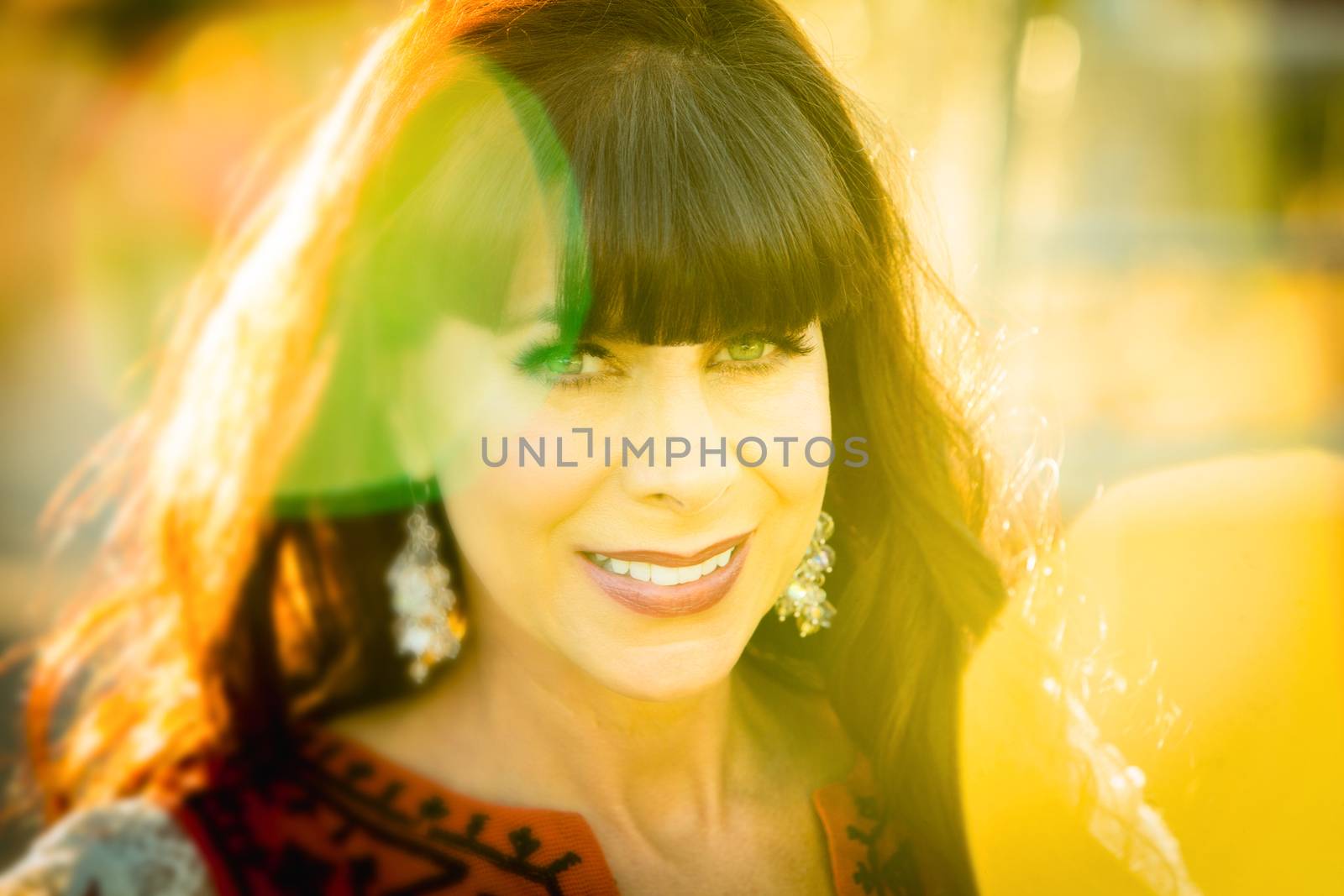 Close up on joyful smiling single woman surrounded by bright light glaring in lens