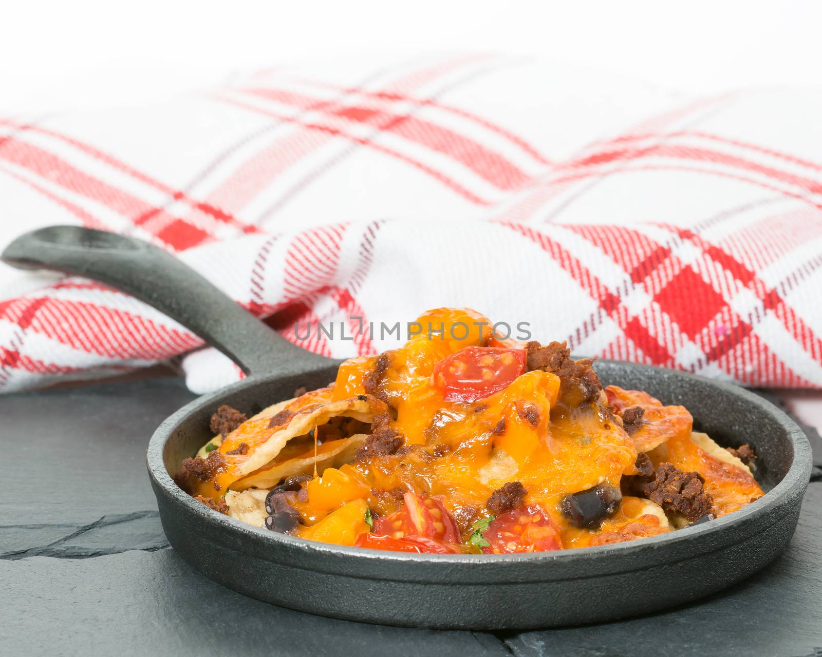 Delicious nachos served in a small cast iron fry pan.