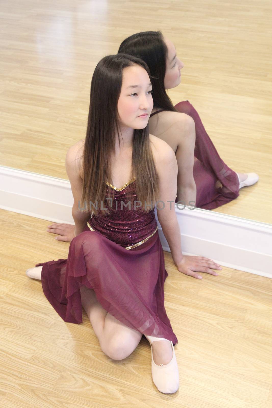 Beautiful brunette teen dancer in a burgundy costume