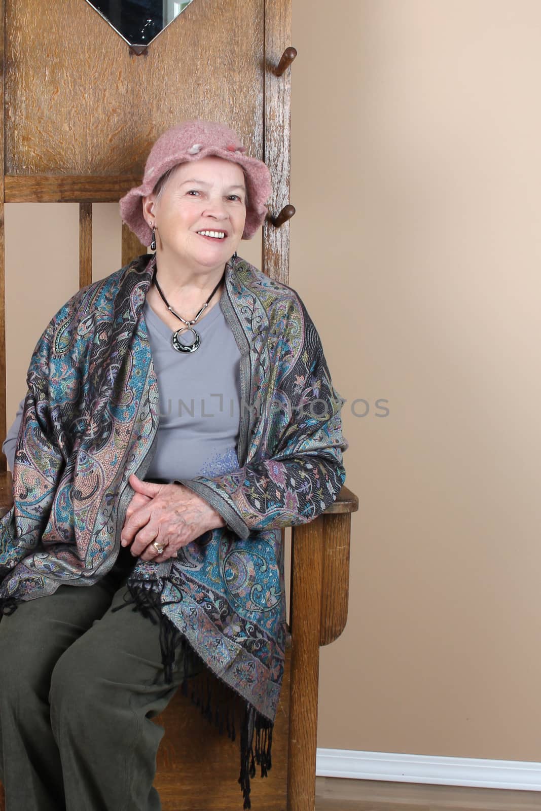 Senior lady wearing a pink hat in studio setting