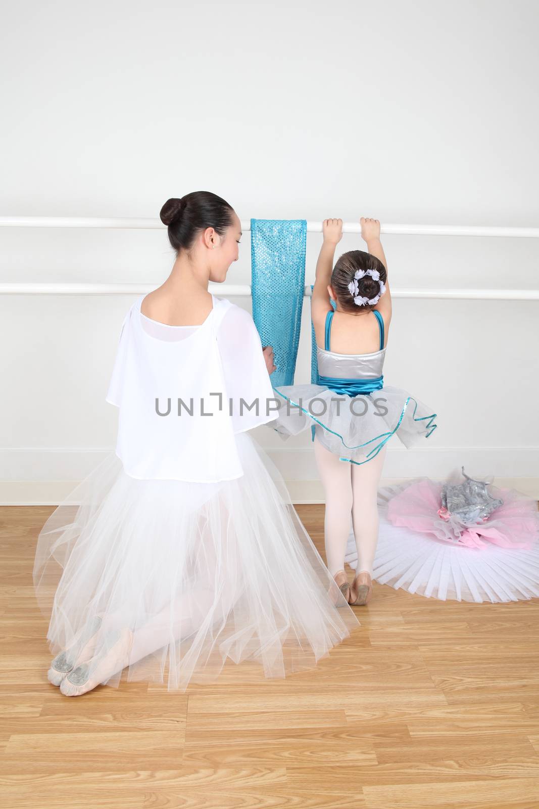 Teen dancer and toddler in costume at dance studio