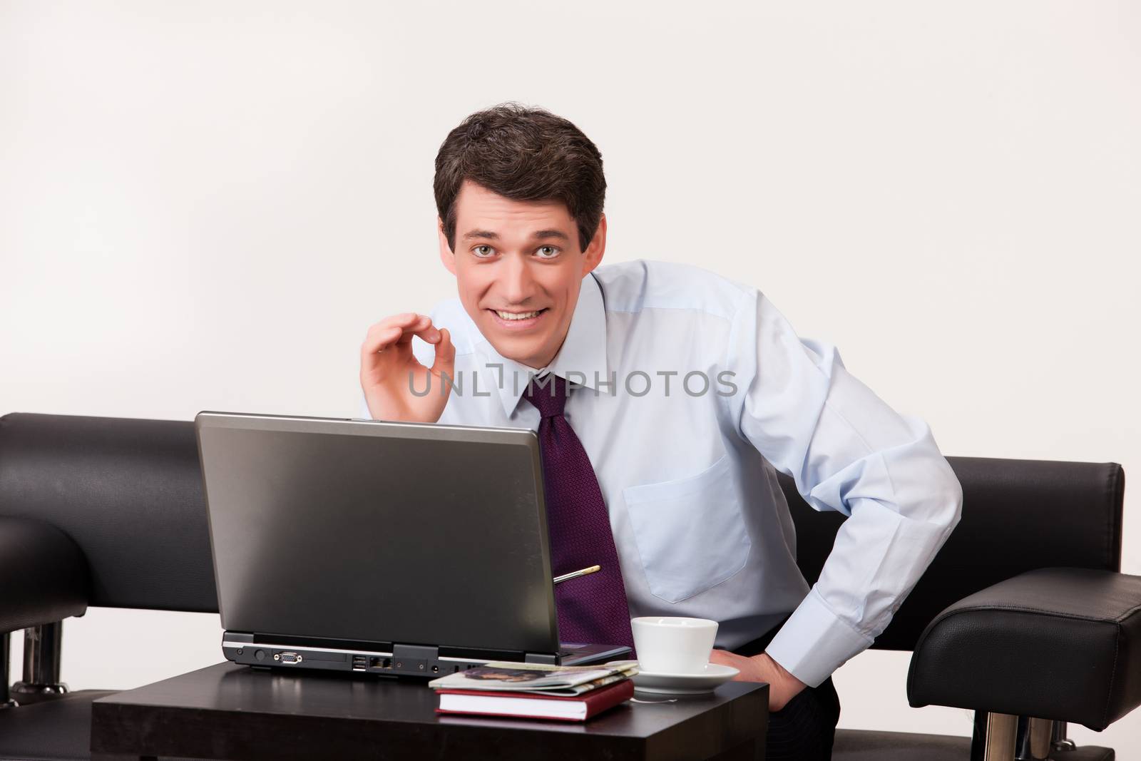 Young businessman working at the computer on isolated background
