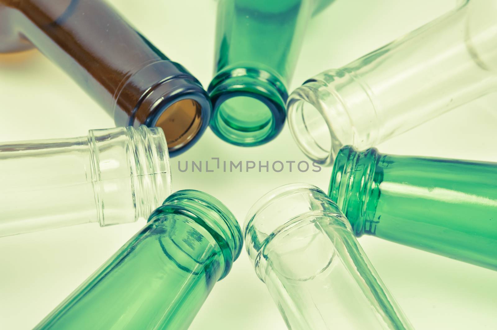 Empty glass bottles of mixed colors including green, clear white, brown