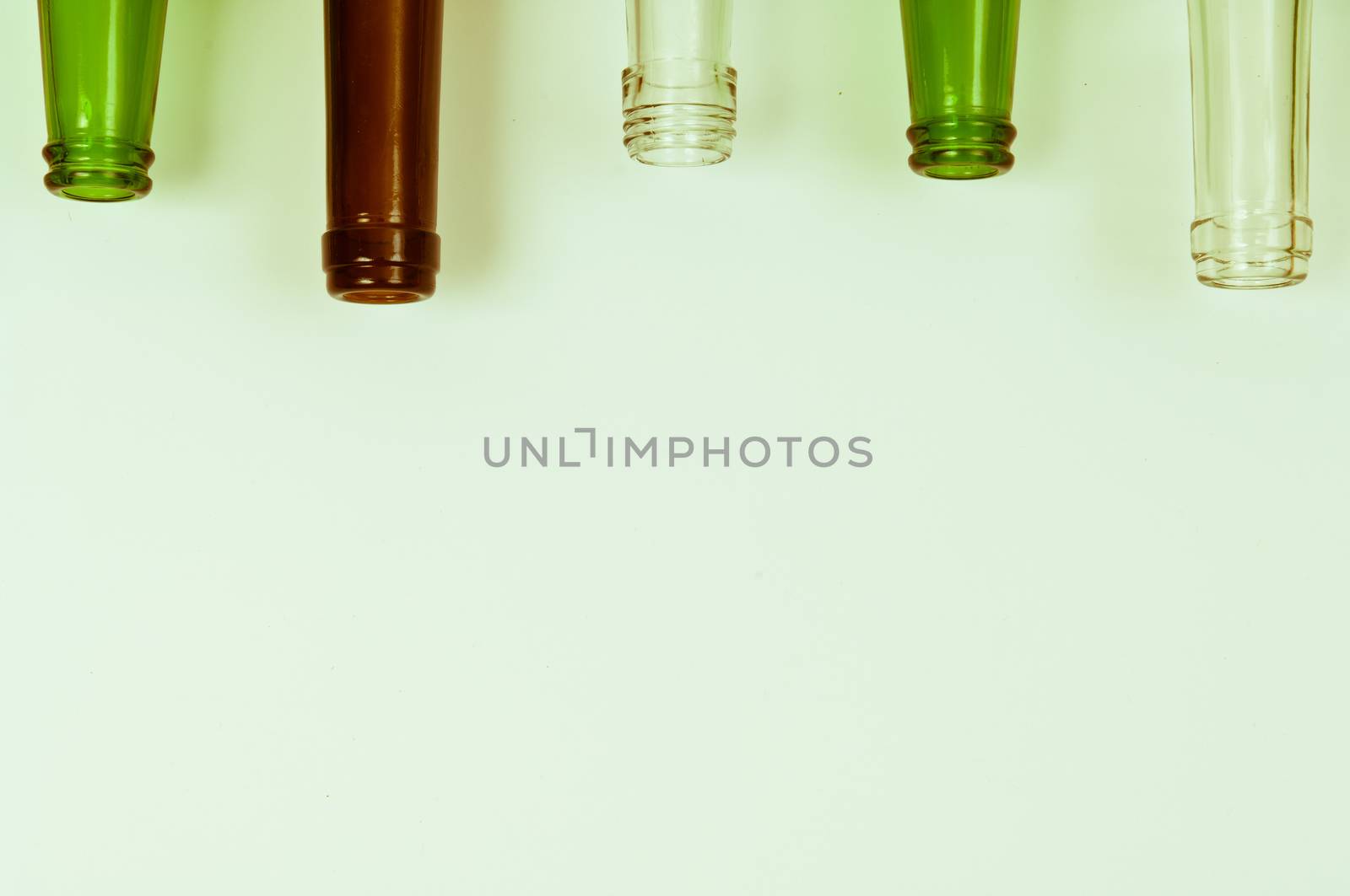 Empty glass bottles of mixed colors including green, clear white, brown
