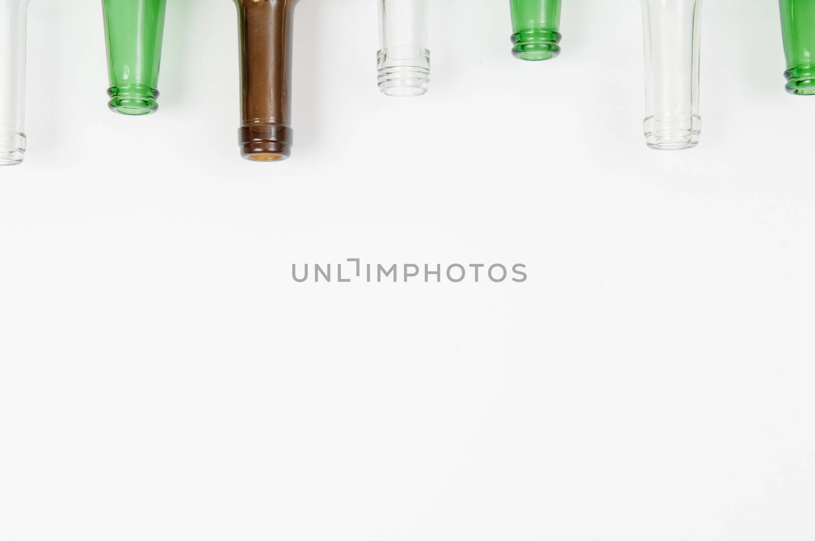 Empty glass bottles of mixed colors including green, clear white, brown