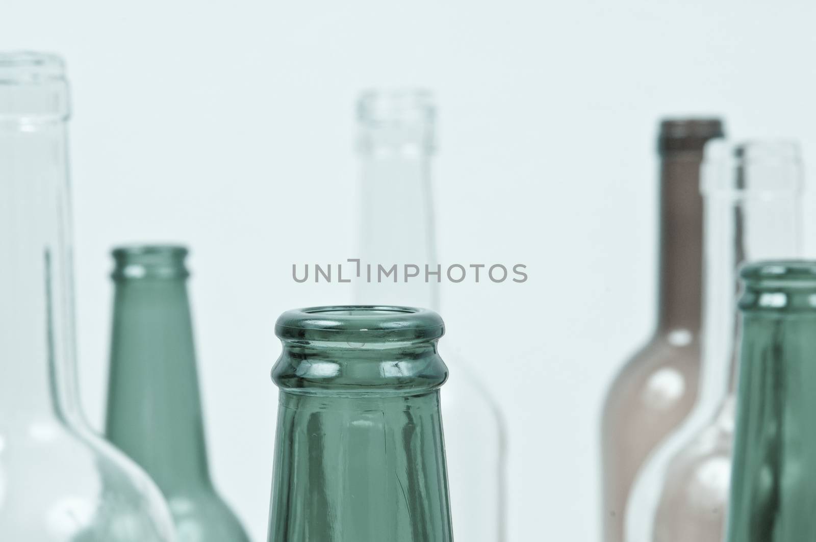 Empty glass bottles of mixed colors including green, clear white, brown