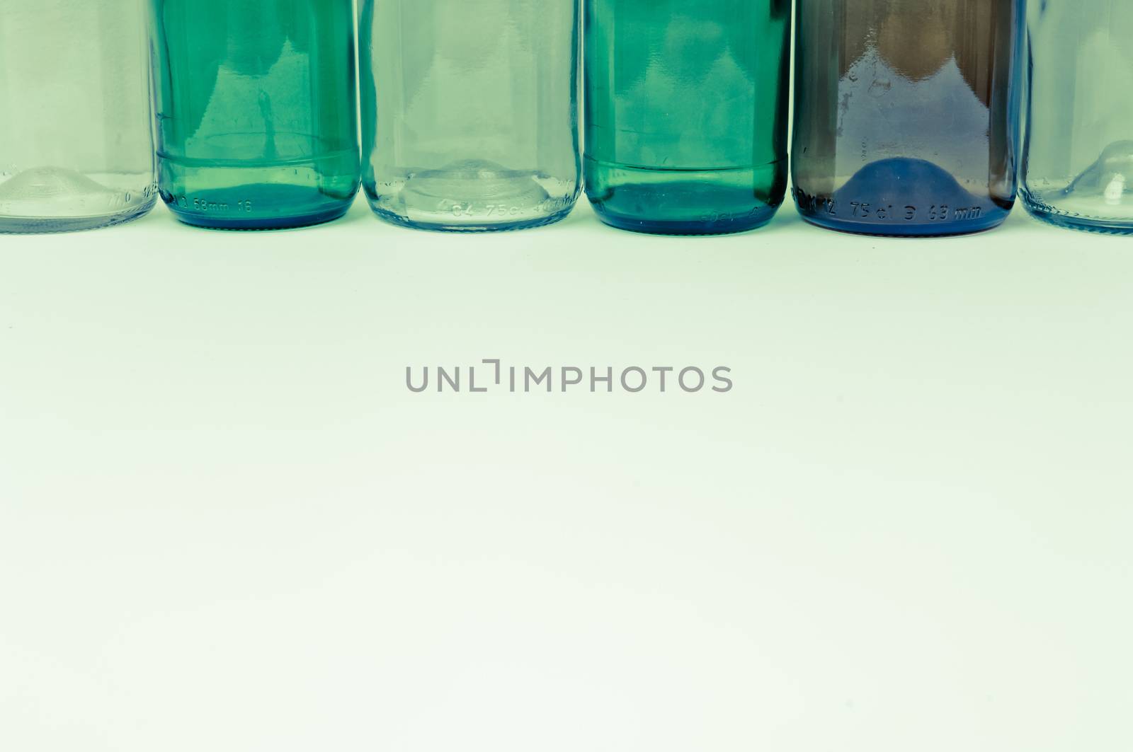 Empty glass bottles of mixed colors including green, clear white, brown