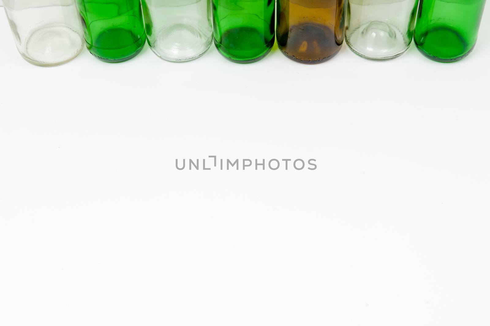 Empty glass bottles of mixed colors including green, clear white, brown