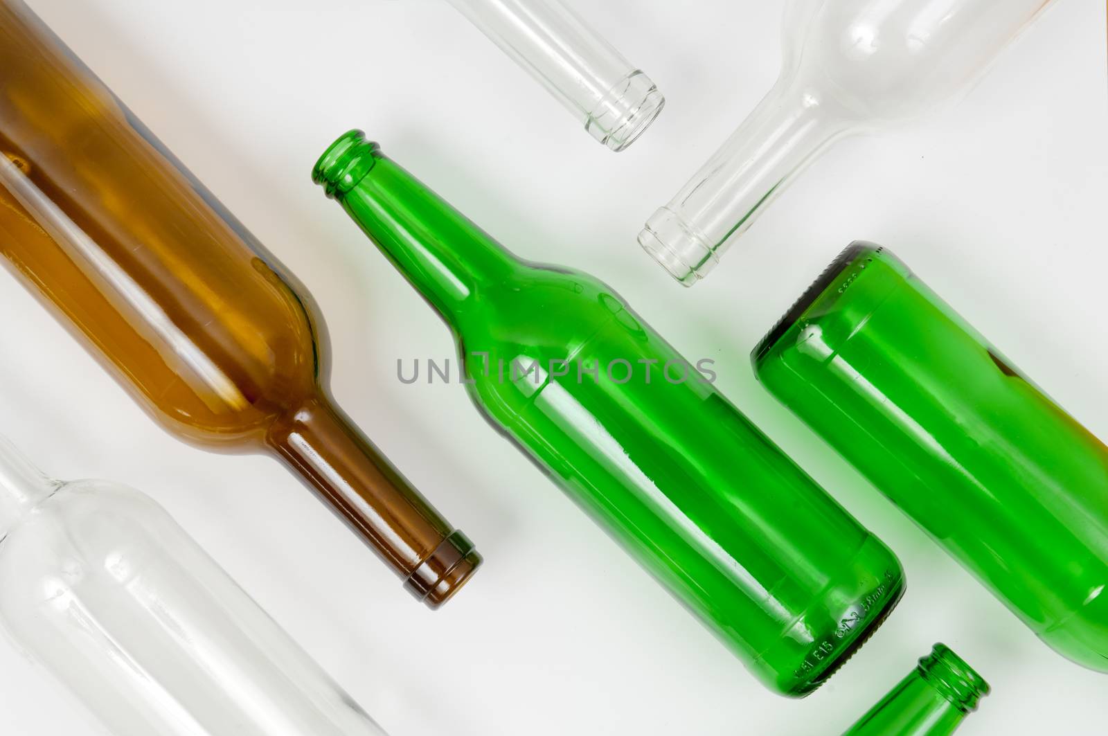 Empty glass bottles of mixed colors including green, clear white, brown