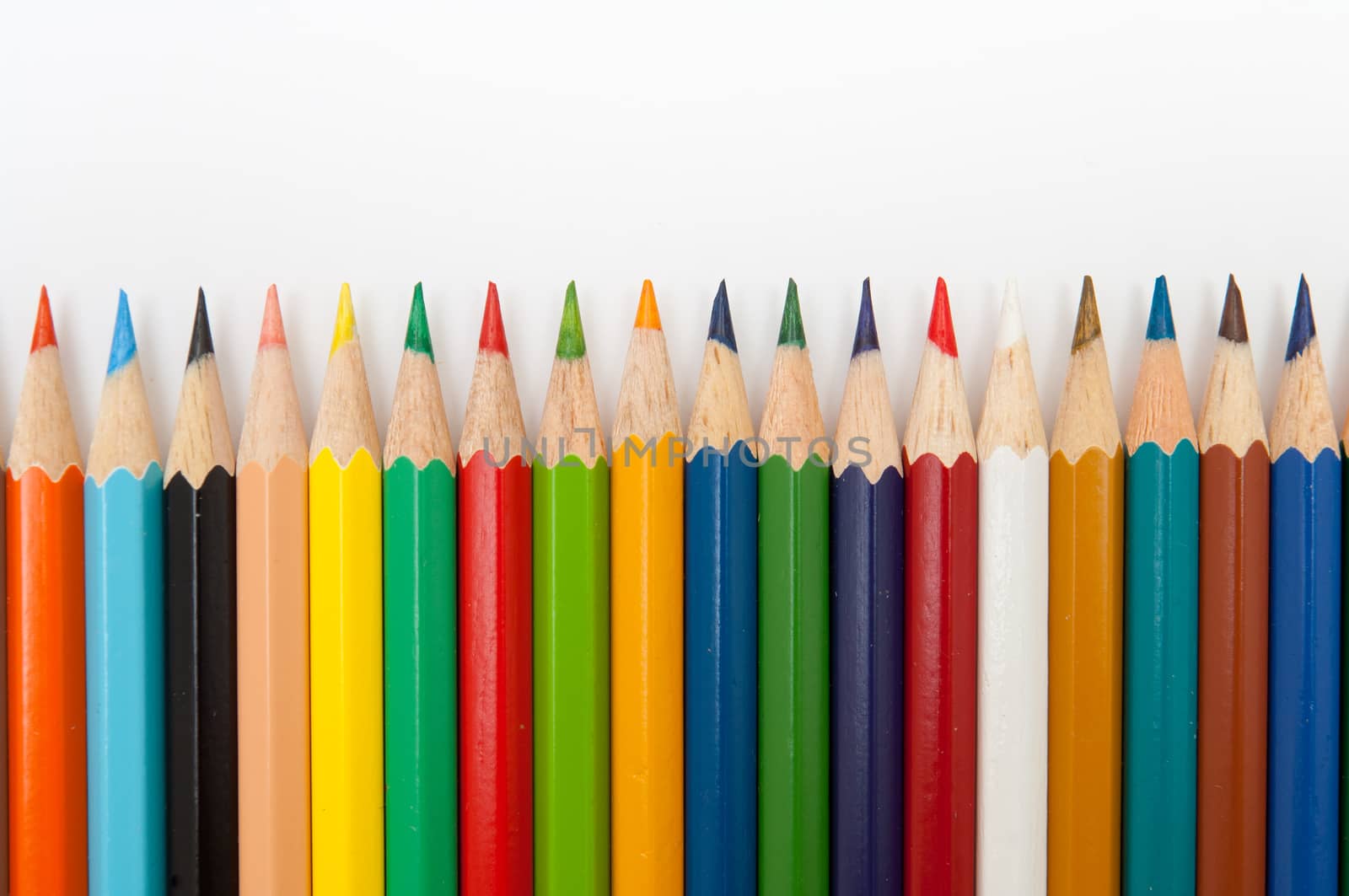 Pattern of color pencils isolated on white background close up