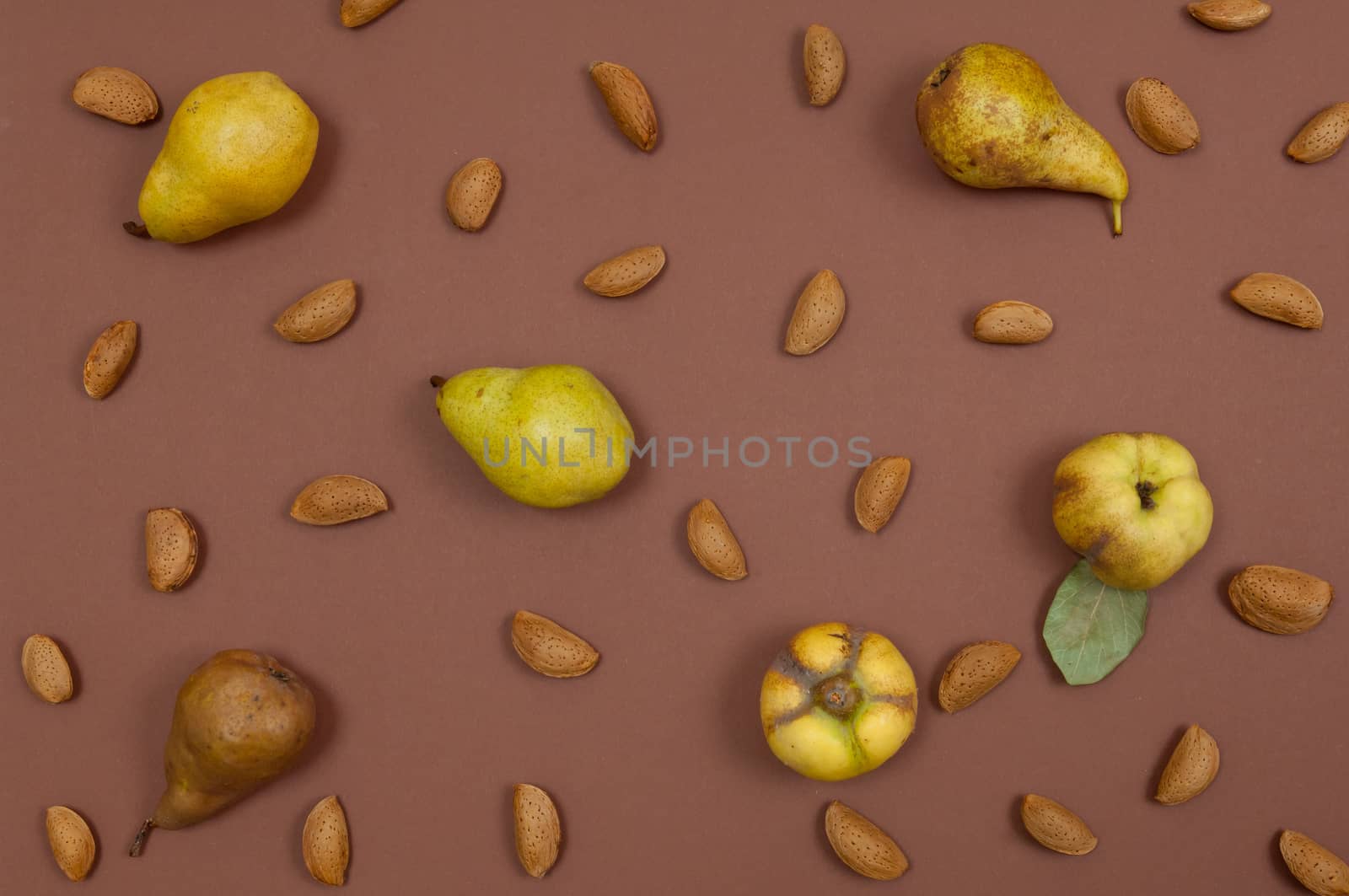 Autumn pear and nut pattern on brown background top view horizontal
