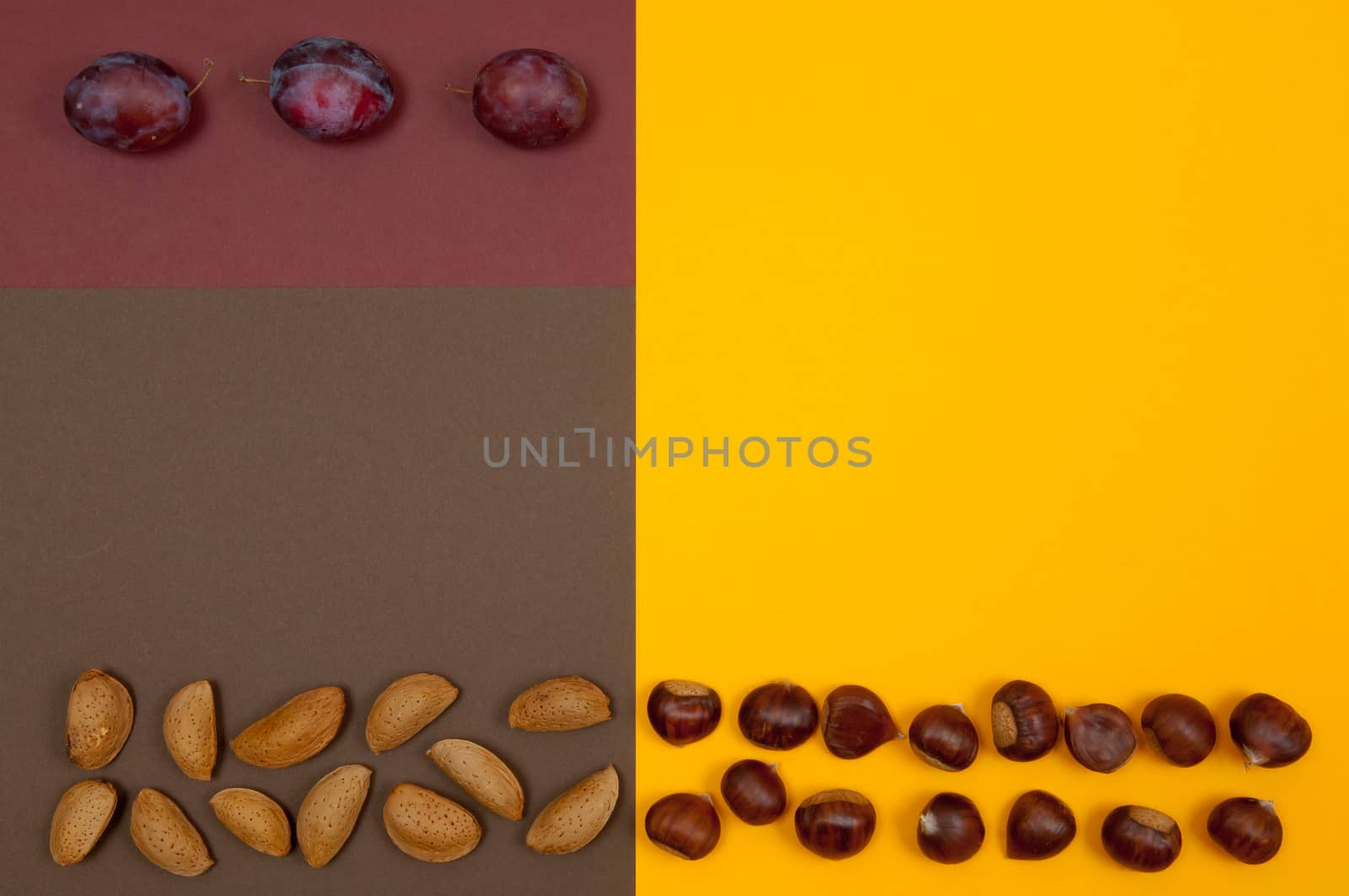 Hard shell nuts and plums on split background by horizonphoto