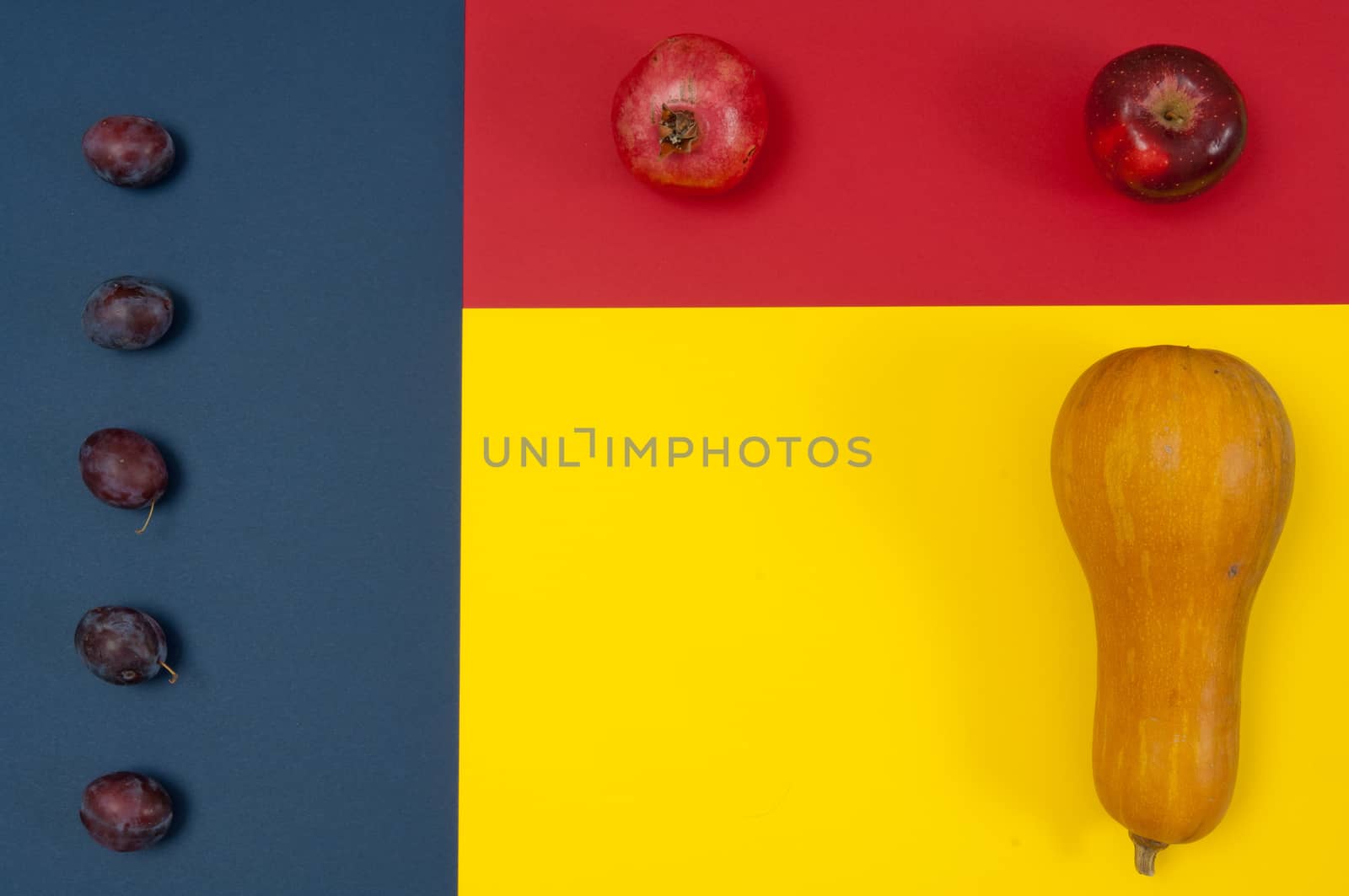 Organic autumn fruits and nuts isolated on split background with copy space