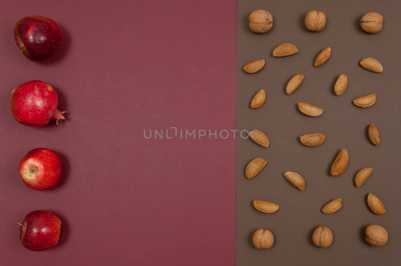 Organic autumn fruits and nuts isolated on split background with copy space
