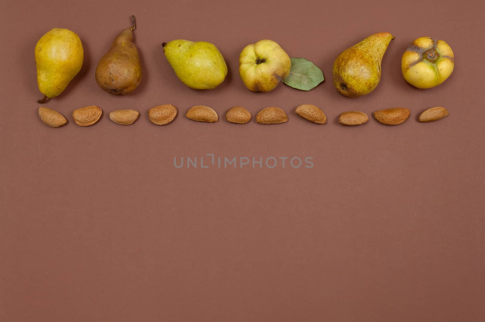 Pears and almonds row on yellow background with copy space by horizonphoto