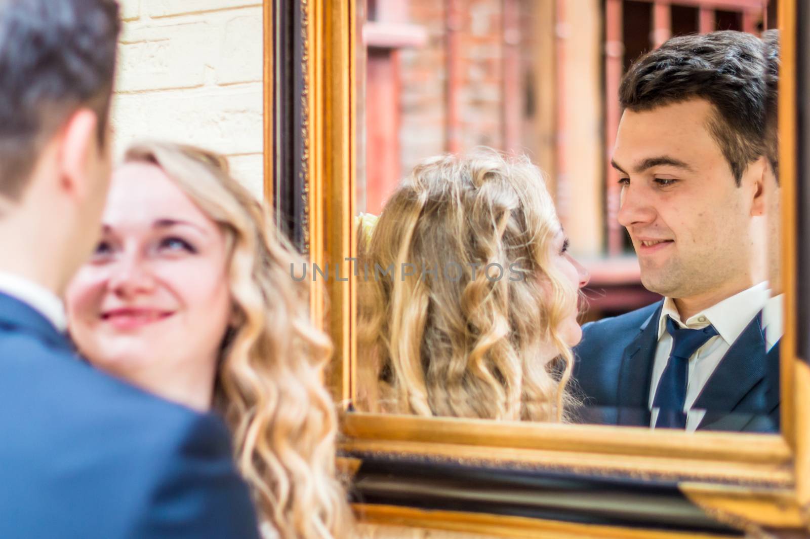 newlyweds near the mirror in the house