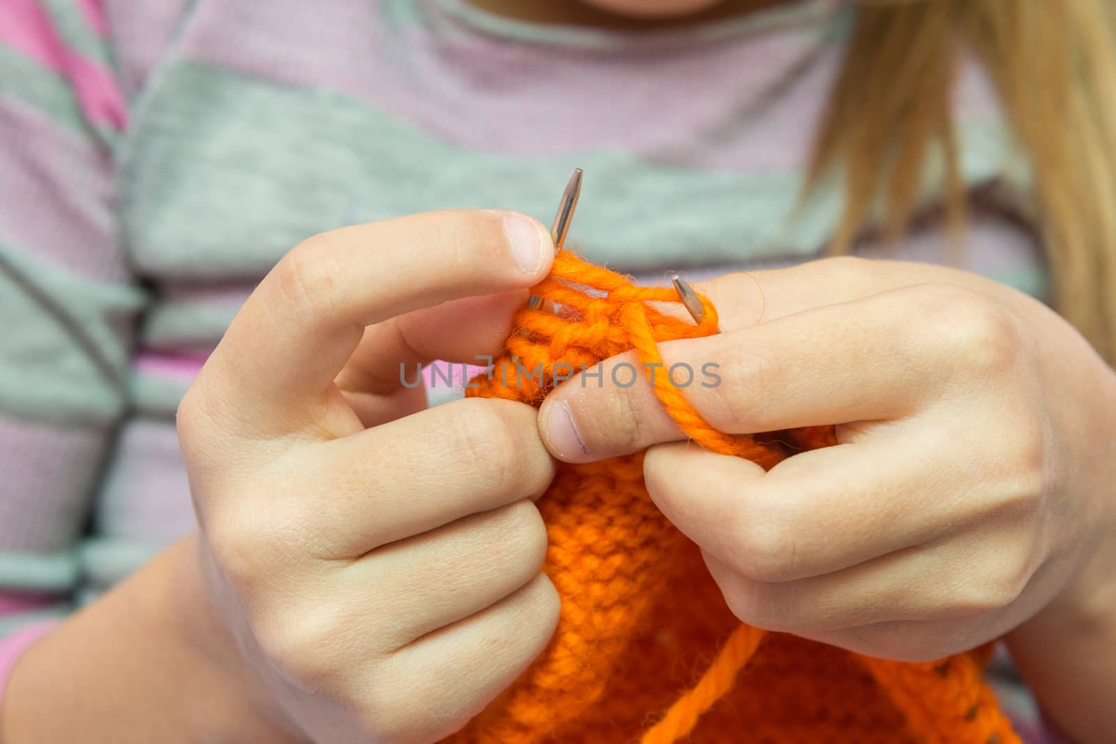 Close-up of children hands to knit with needles by Madhourse